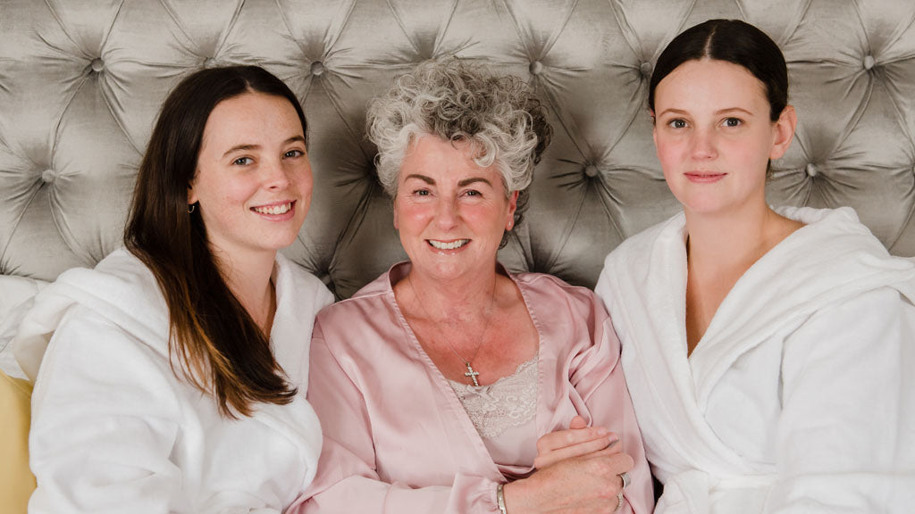 Foto von Maxine, Darcy und Margot Laceby, die auf ihrem Bett sitzen 